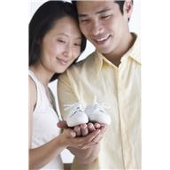 Asian Couple Looking For Baby Shoes In Their Hand
