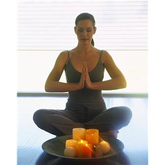 Women Sitting In Yoga Poses With Candles